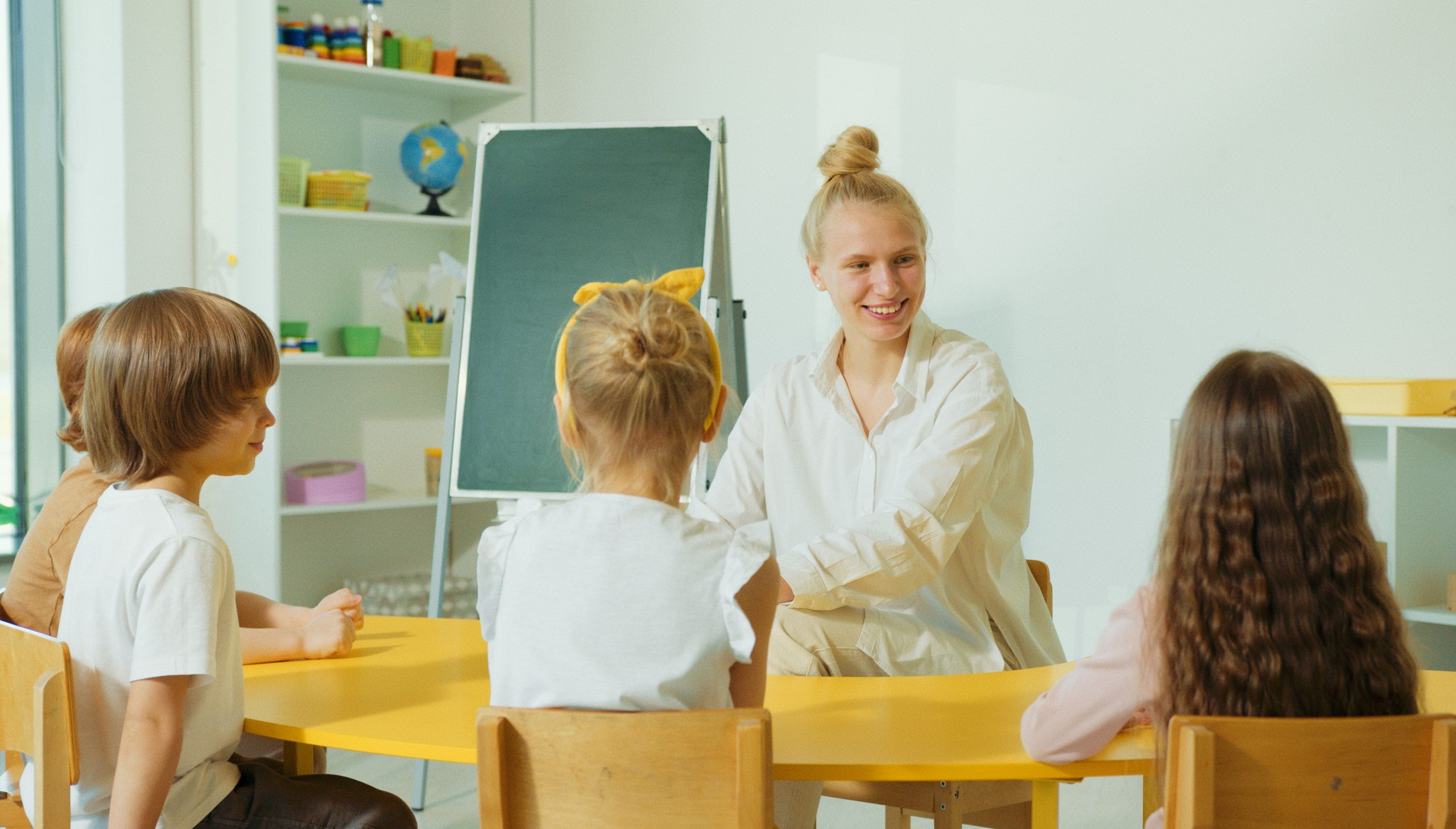 Enseignante interagissant avec enfants en classe colorée