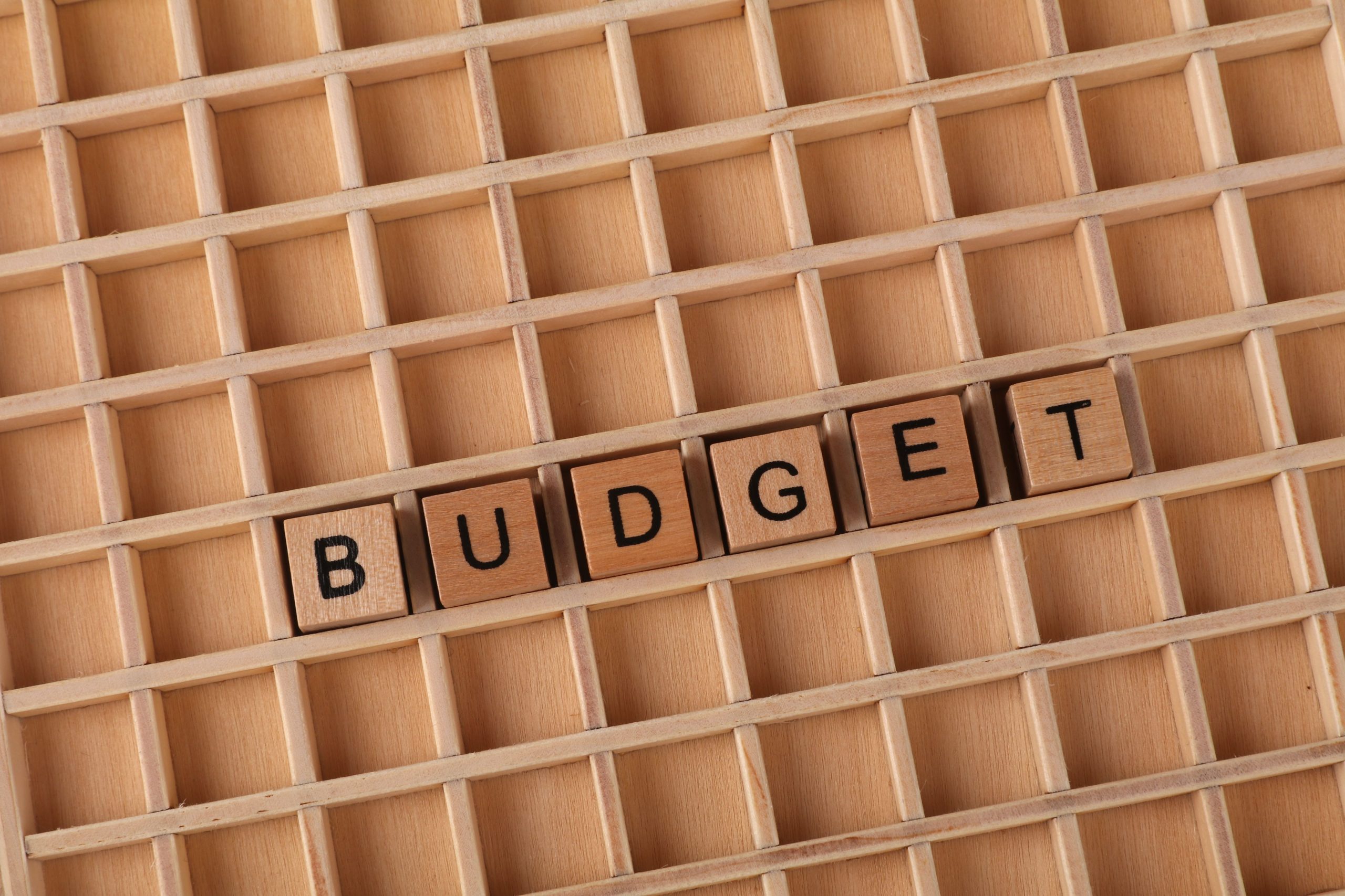 Lettres budget sur grille bois symbolisant finances planification