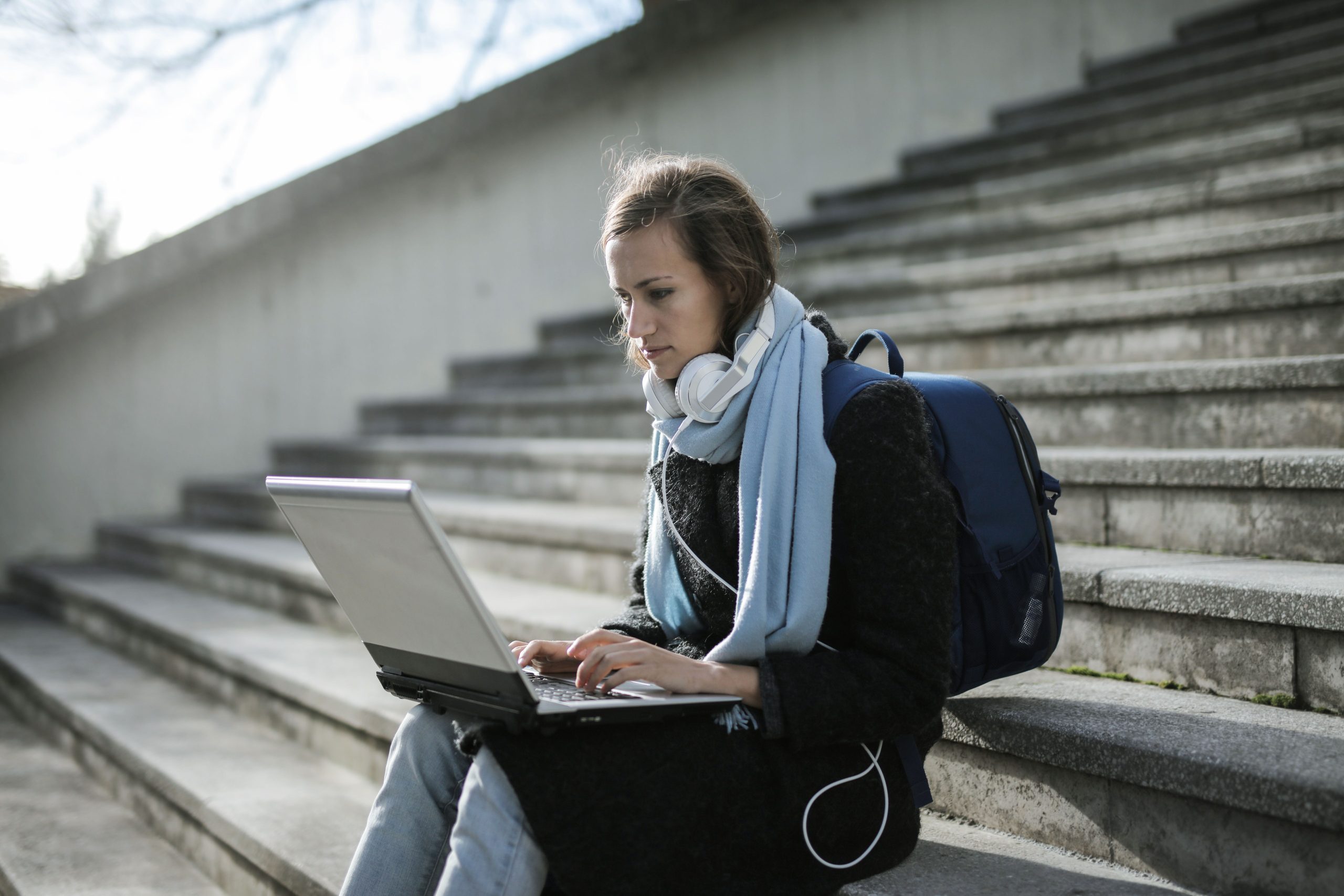 Femme étudiant en ligne sur escaliers extérieurs