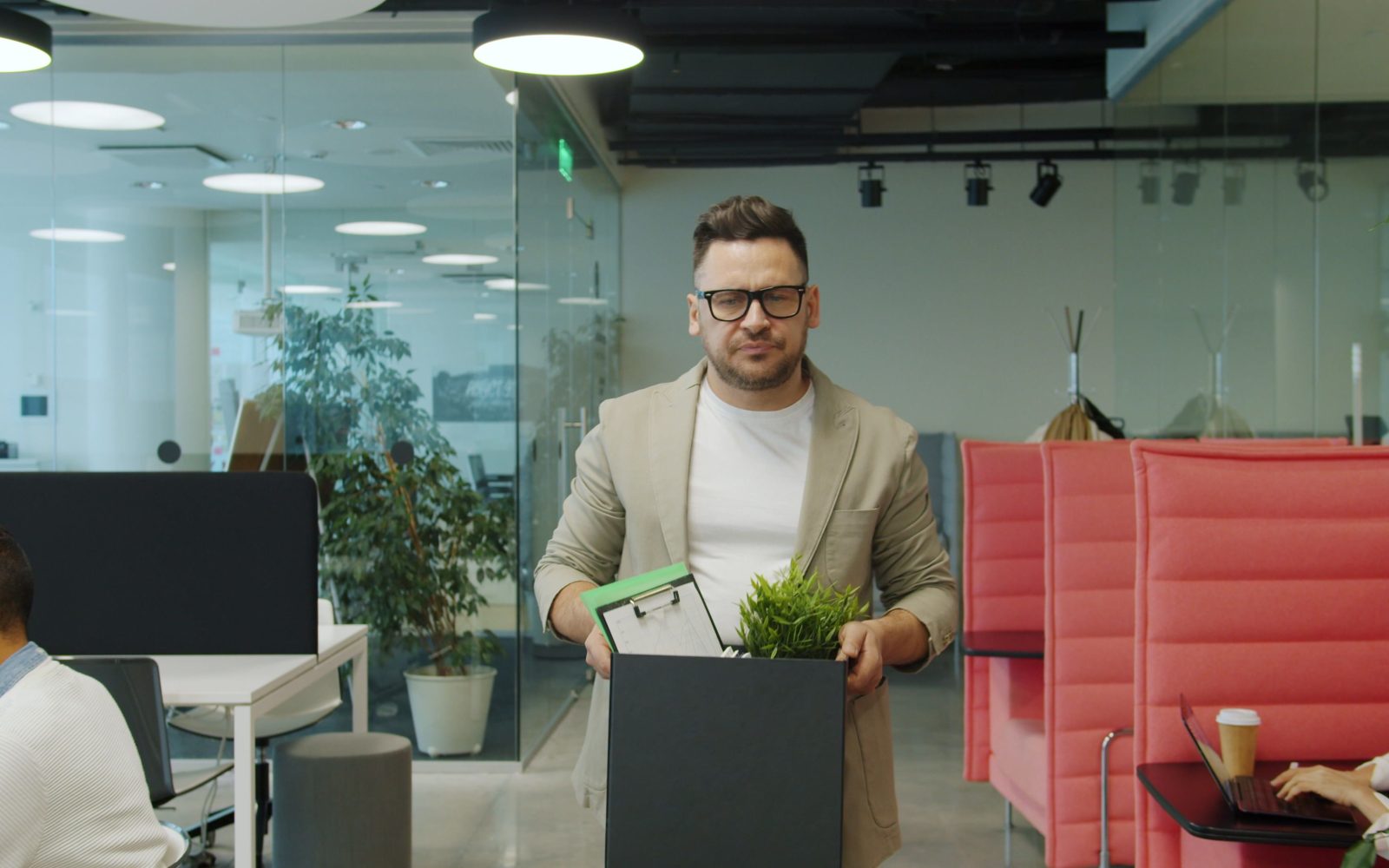 Homme quittant bureau avec carton affaires