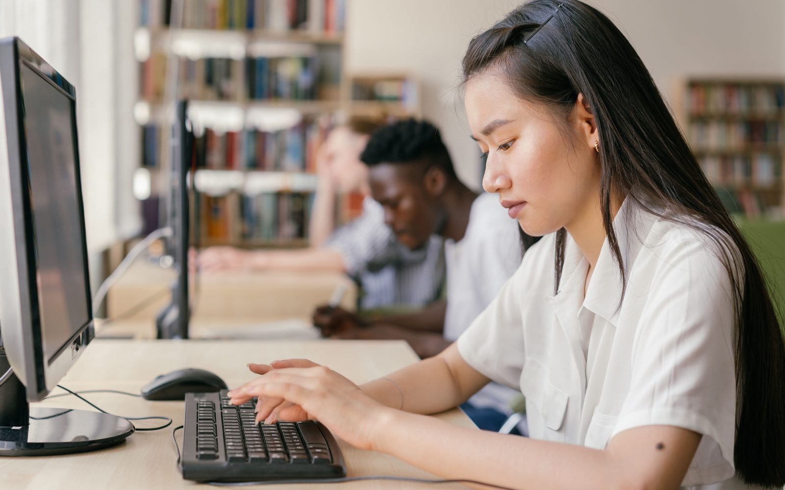 Étudiants travaillant sur ordinateur en bibliothèque