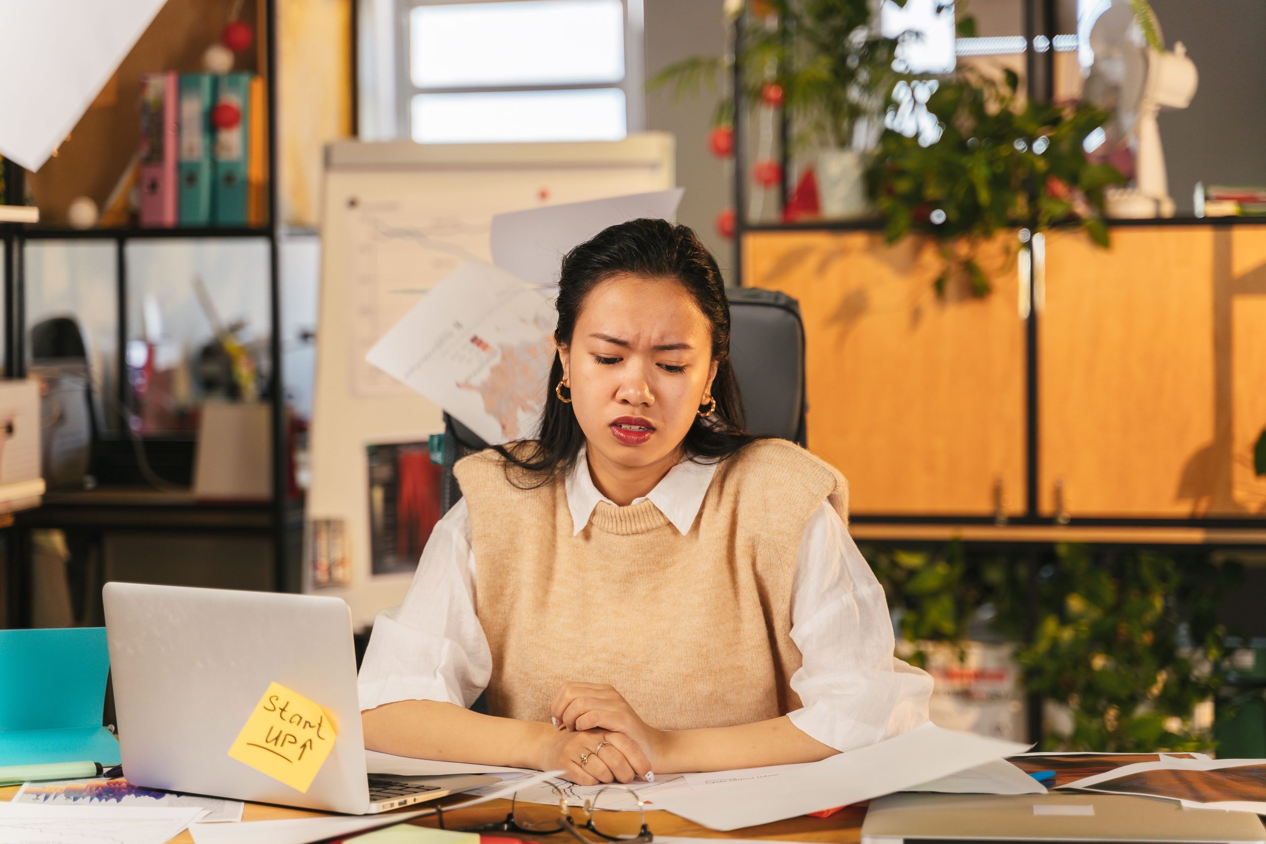 Employé frustré devant son ordinateur encombré