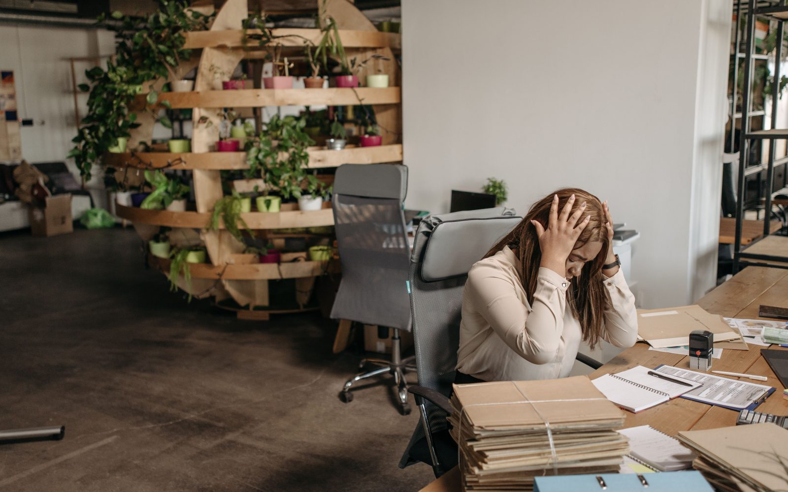 Femme stressée submergée de documents au bureau