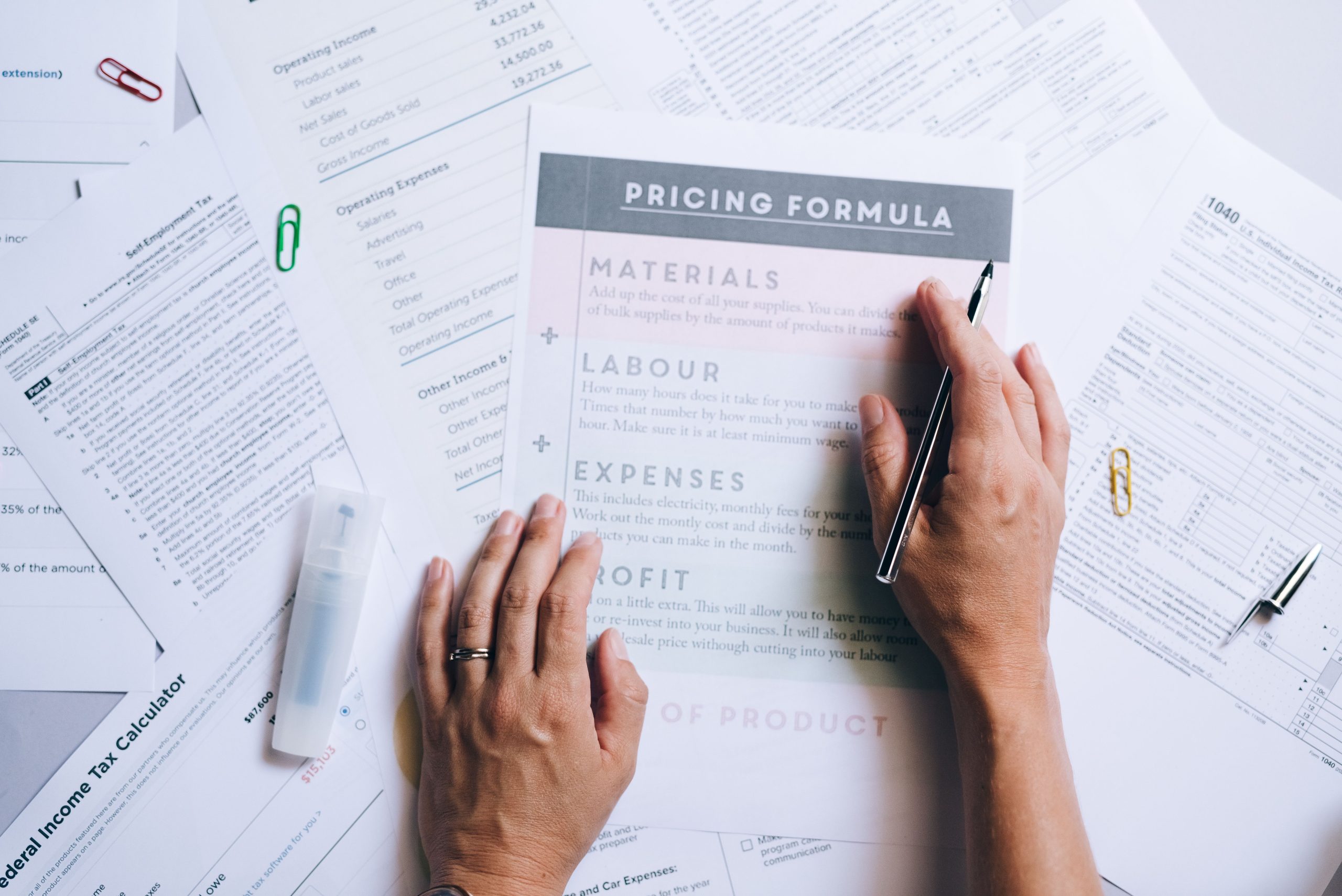Mains organisant documents affaires et formules tarification bureau