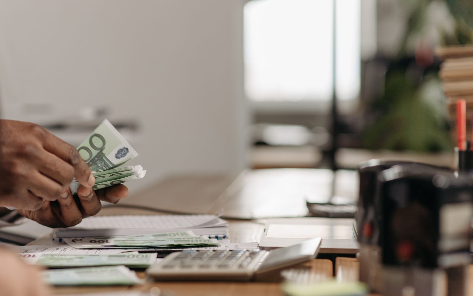 Mains comptant des billets euros au bureau