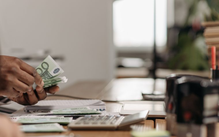 Mains comptant des billets euros au bureau