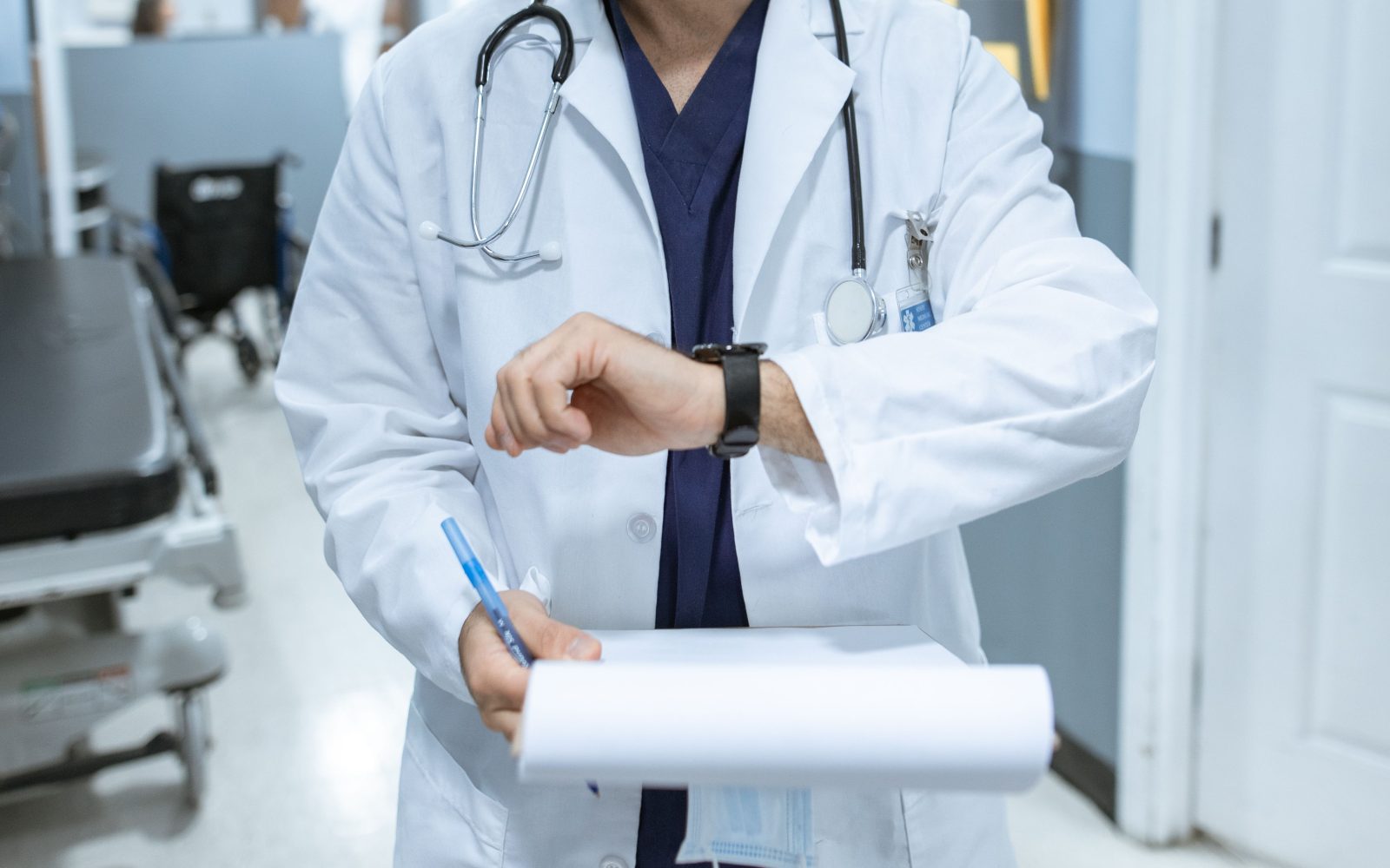 Médecin vérifiant l'heure en corridor hospitalier