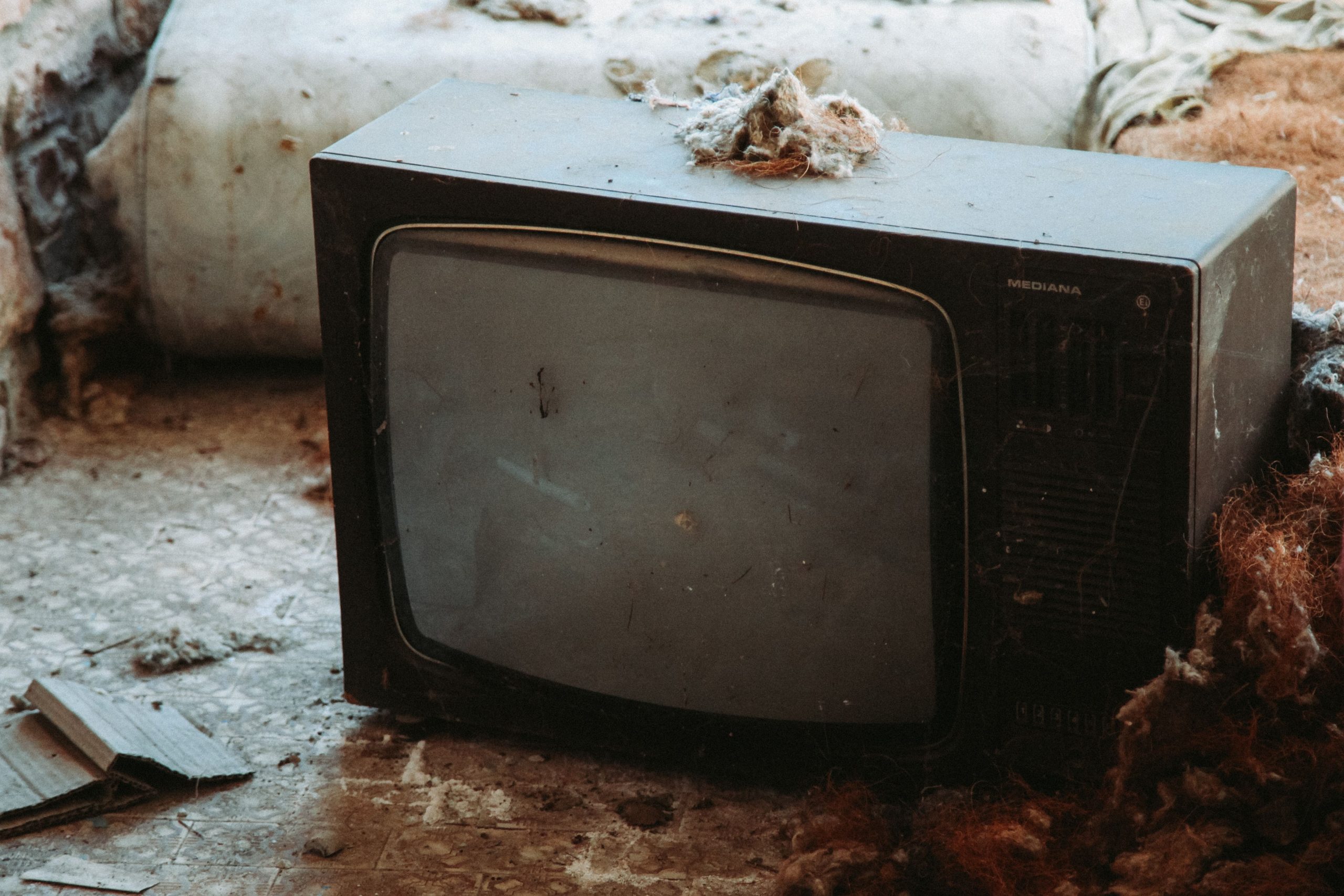 Vieux téléviseur CRT abandonné parmi les débris