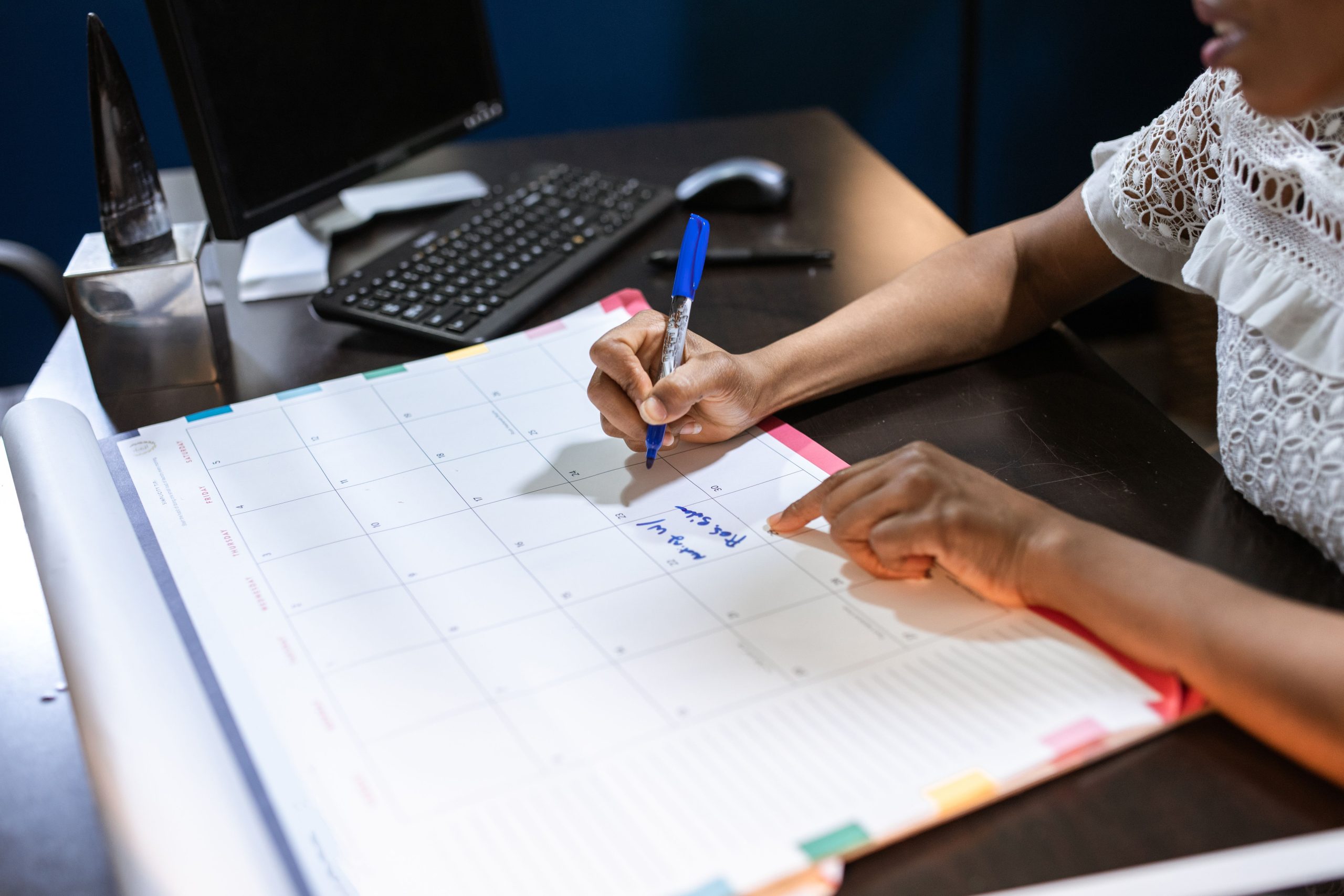 Personne notant des dates importantes dans calendrier