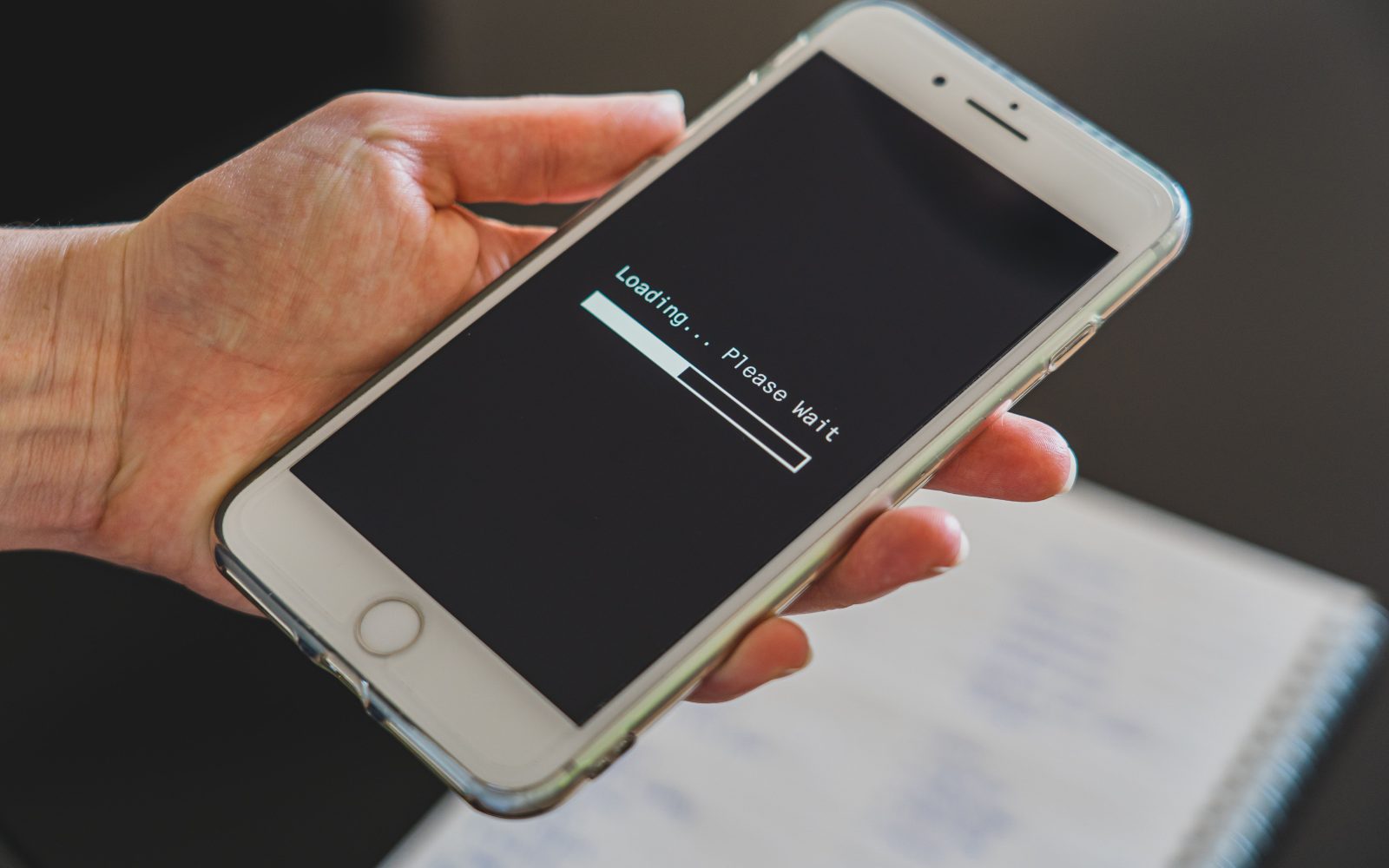 Main tenant smartphone avec écran de chargement