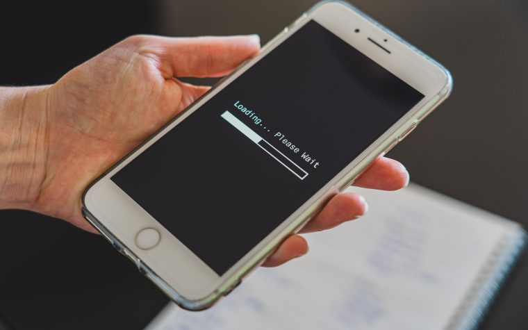 Main tenant smartphone avec écran de chargement