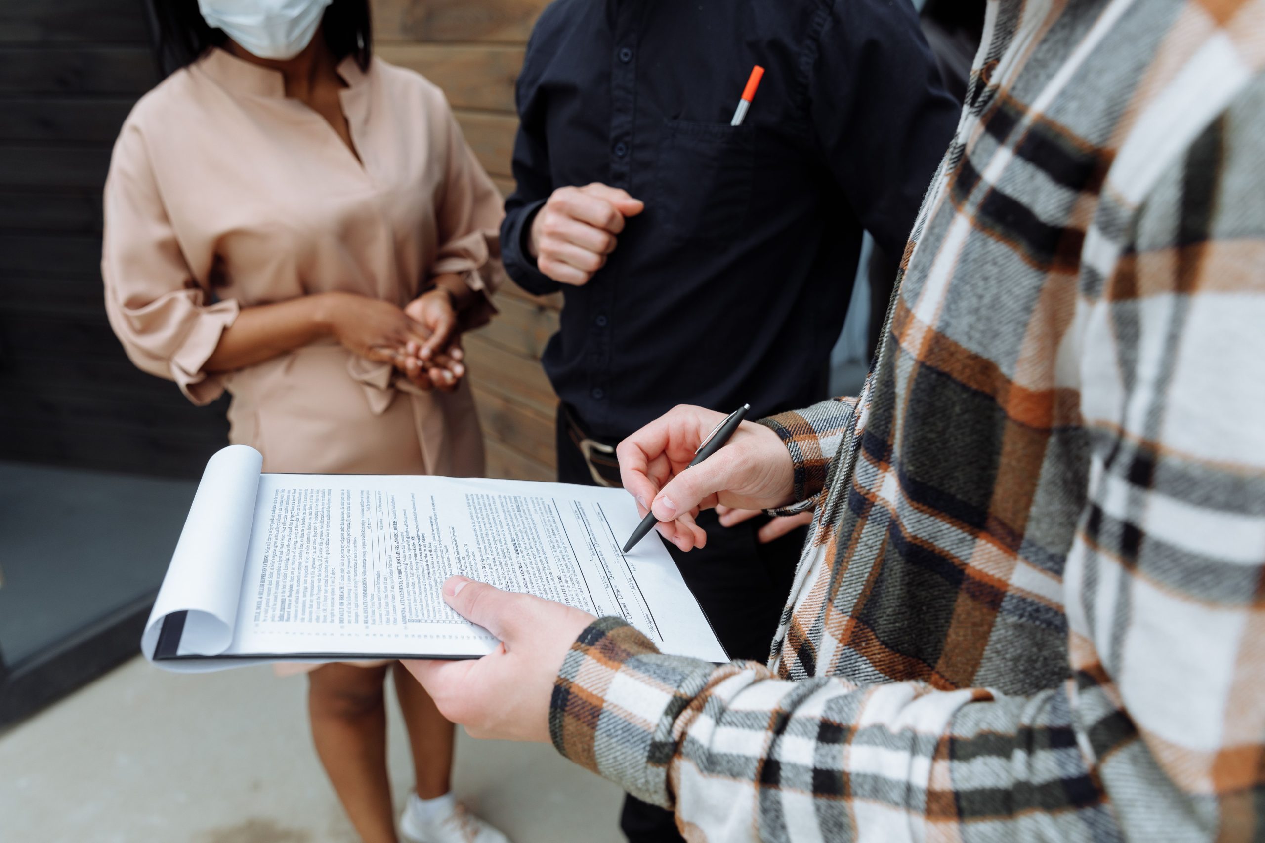 Trois adultes bureau signant document ensemble