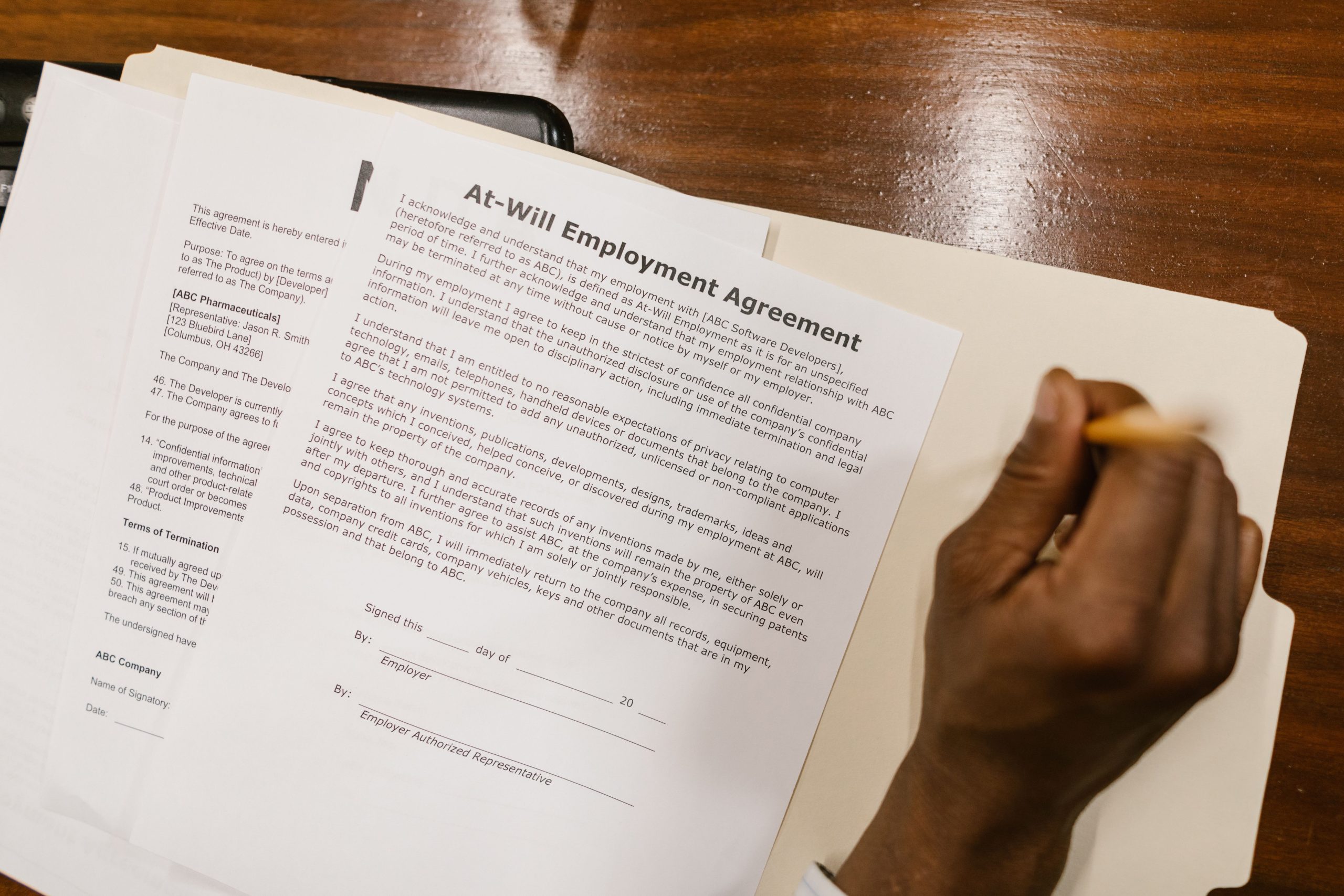 Main signant un contrat CDD sur bureau