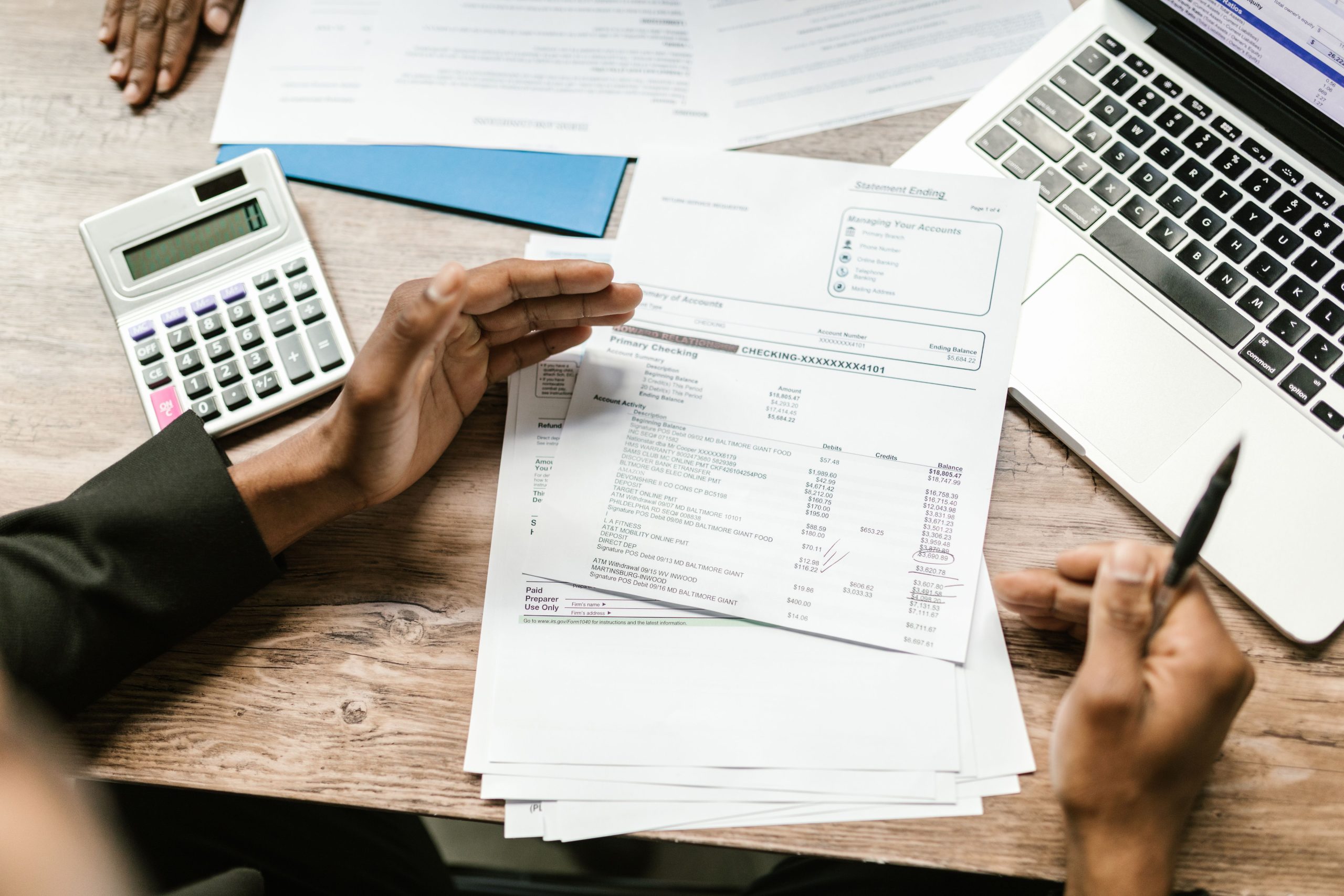 Mains tenant des documents financiers avec calculatrice au bureau