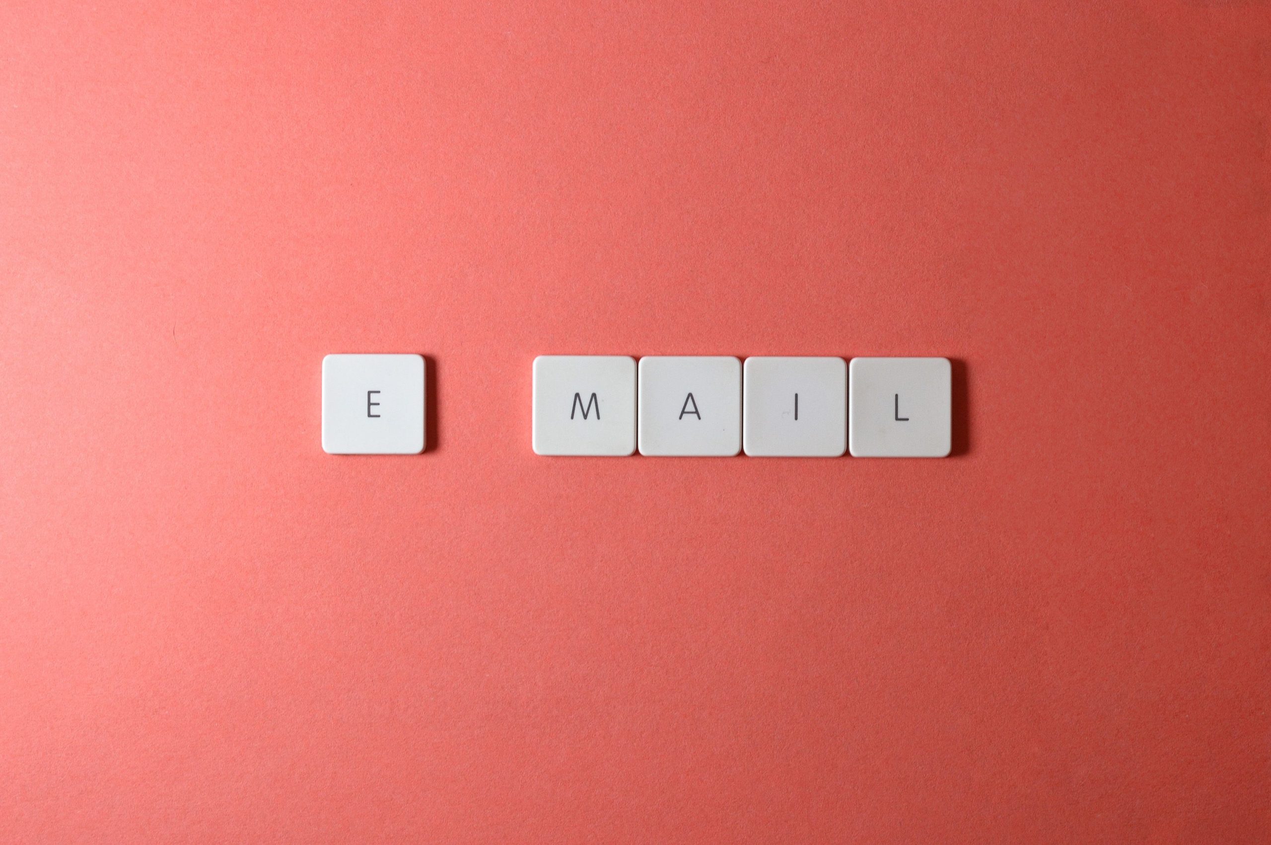 Lettres épelant le mot email sur fond corail