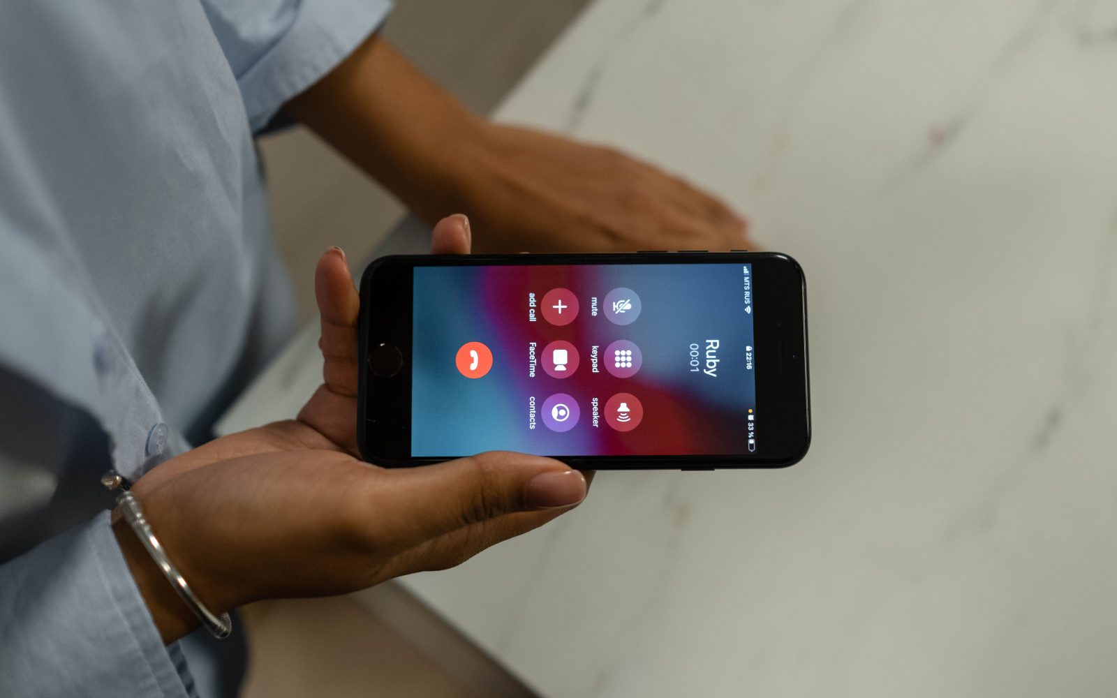 Personne tenant un smartphone avec appel entrant