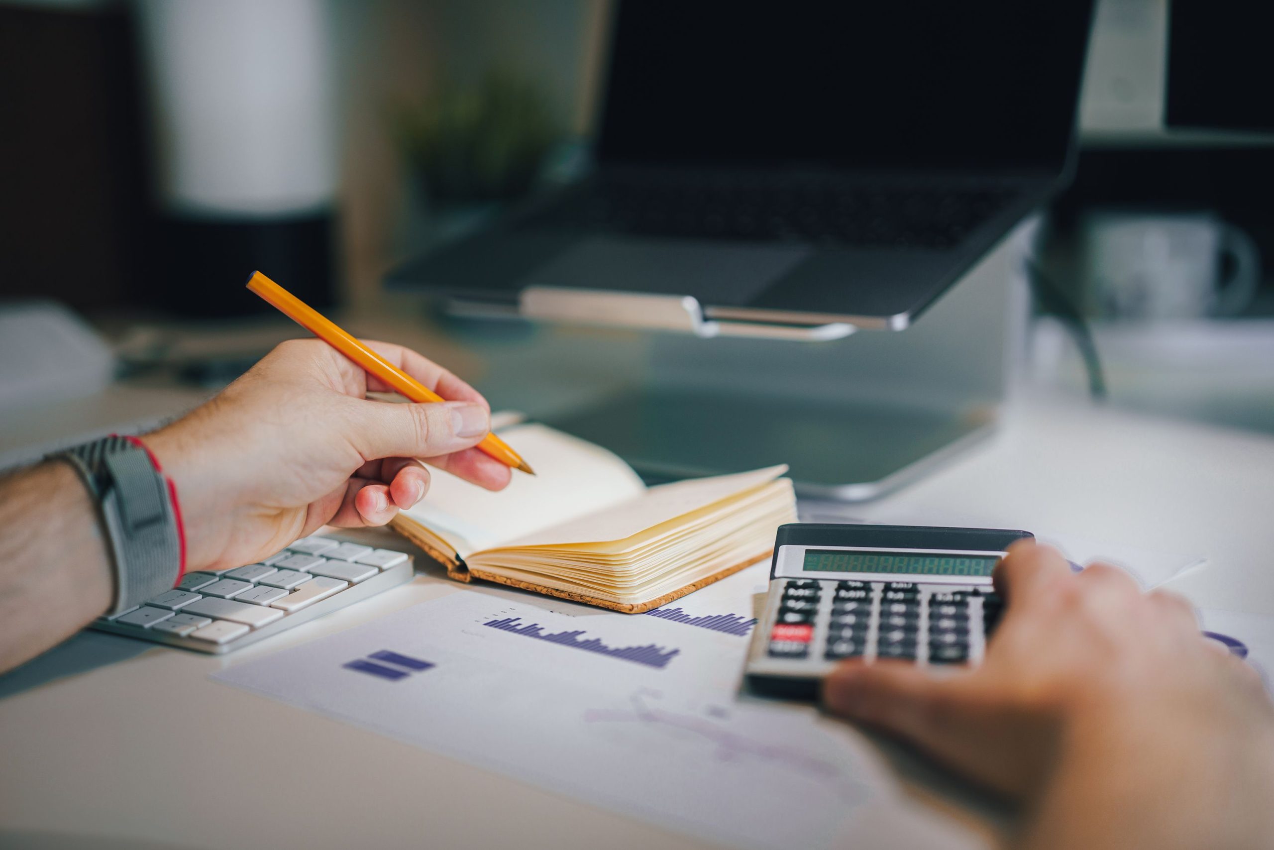 Mains calculant salaire et notes sur bureau