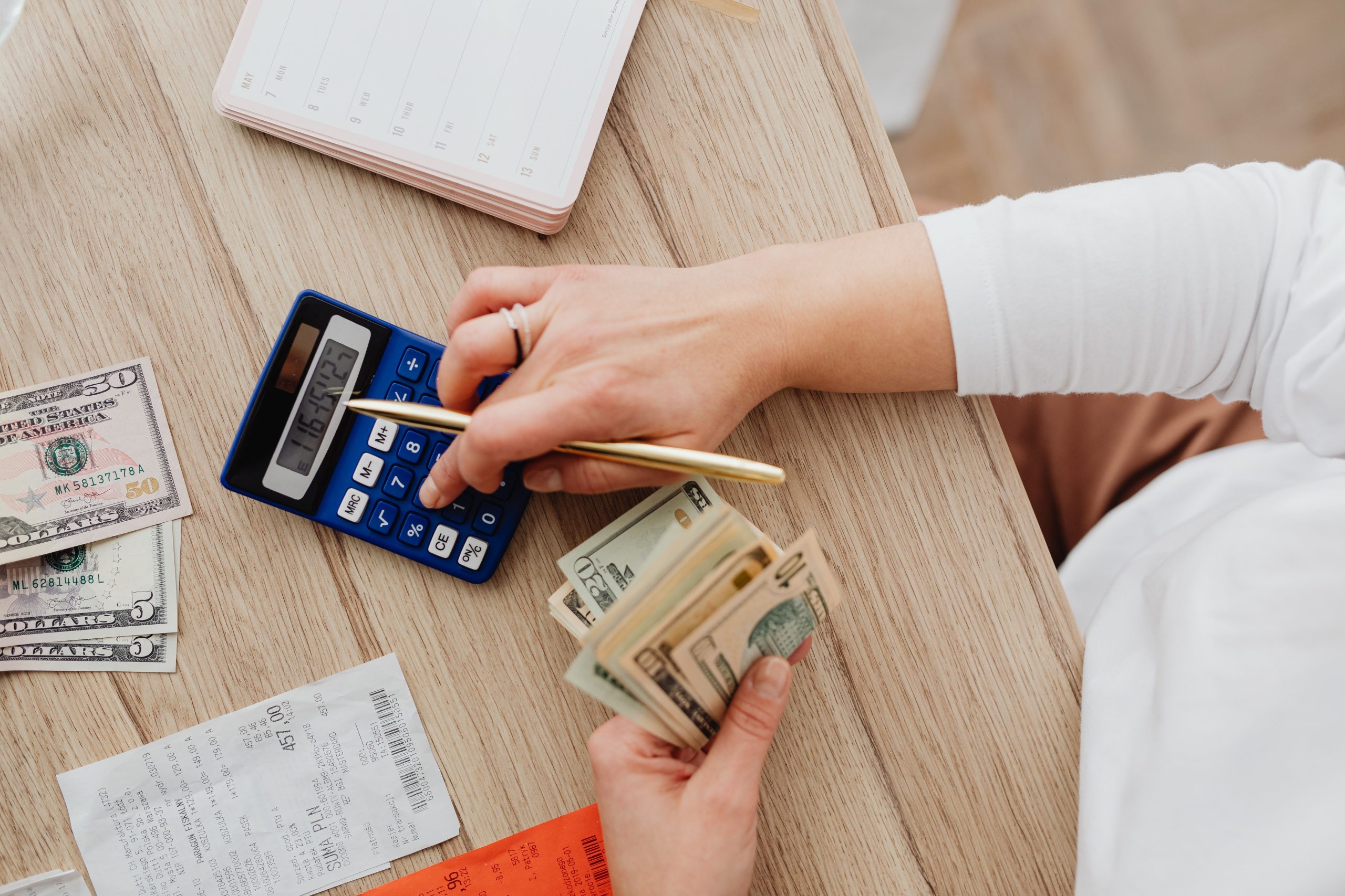 Calculatrice et billets sur une table en bois