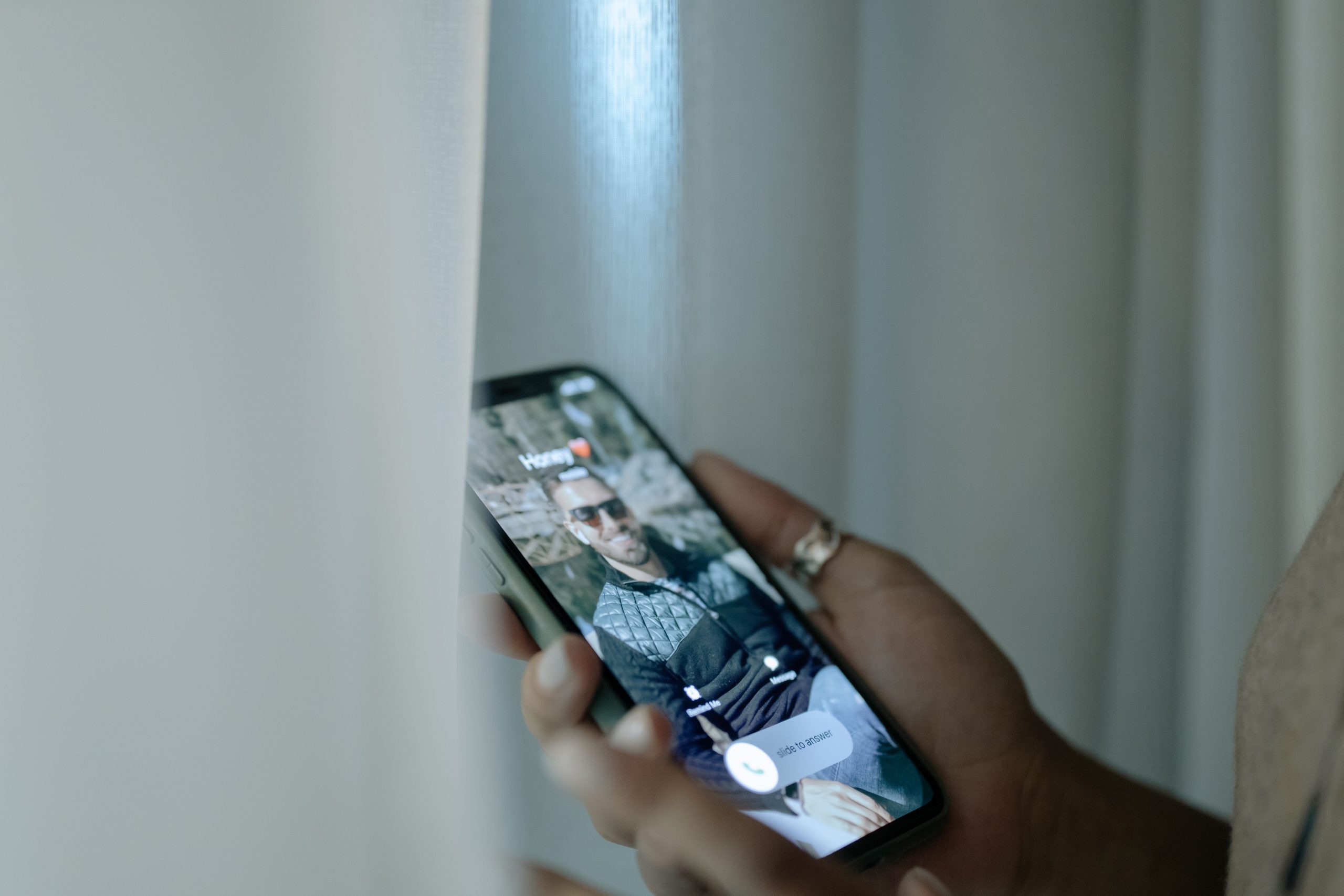 Main tenant un smartphone affichant un appel entrant