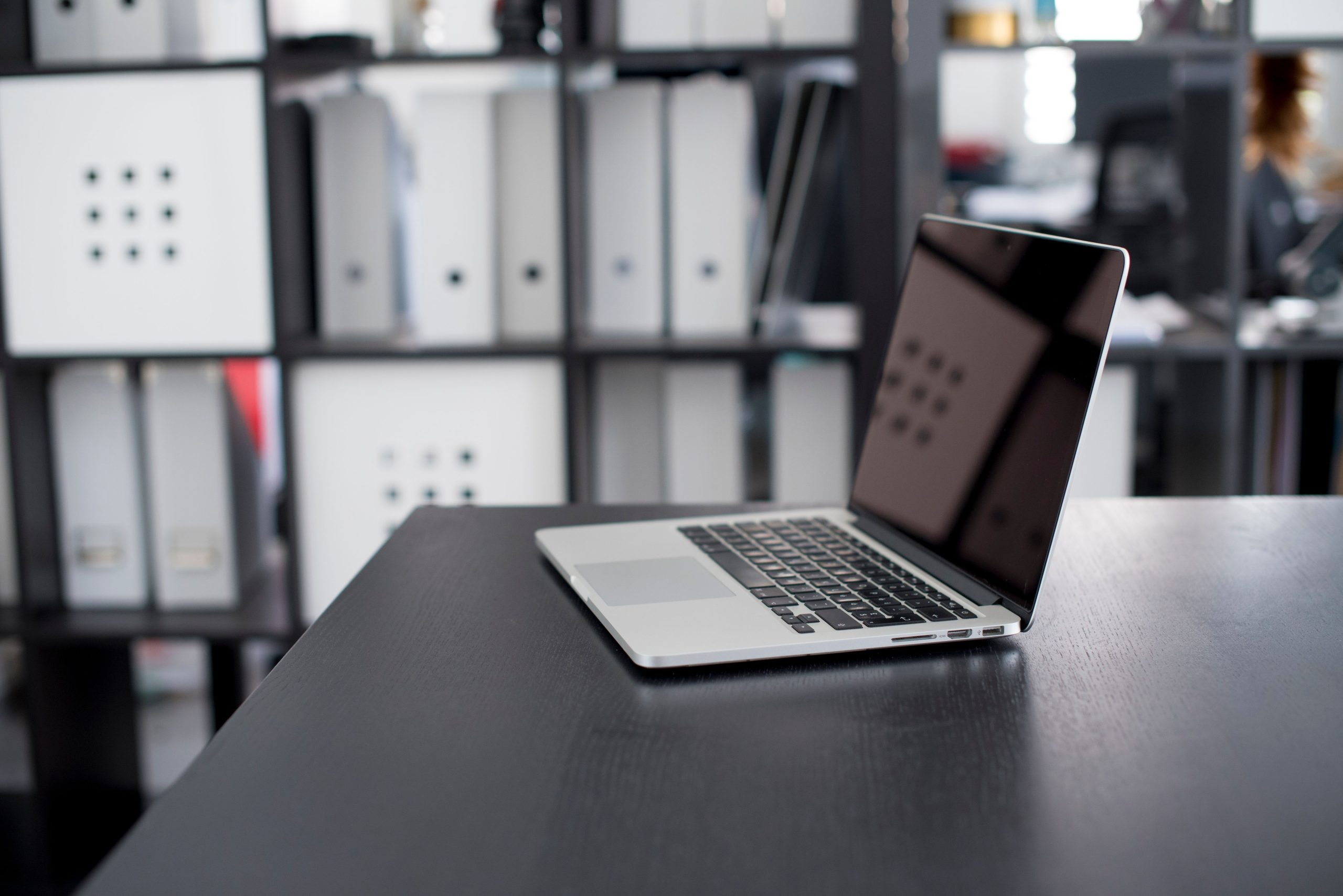MacBook Pro sur un bureau minimaliste avec étagères