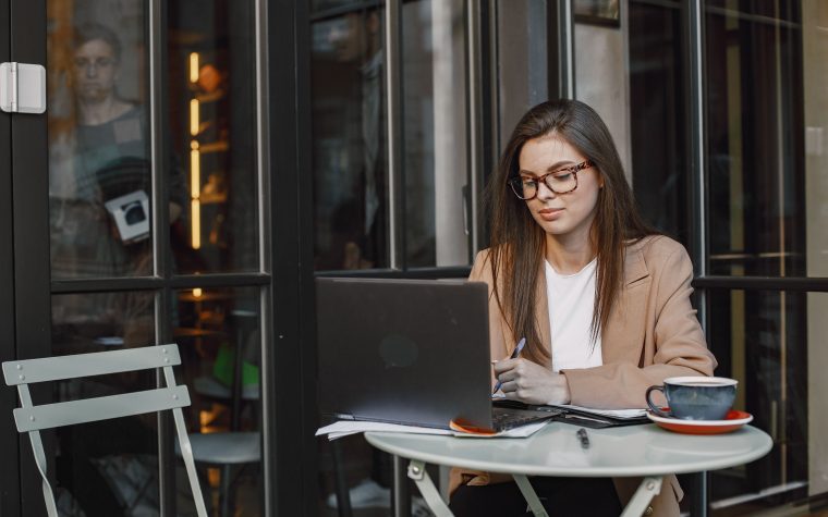 Femme en tenue professionnelle travaillant en freelance au café