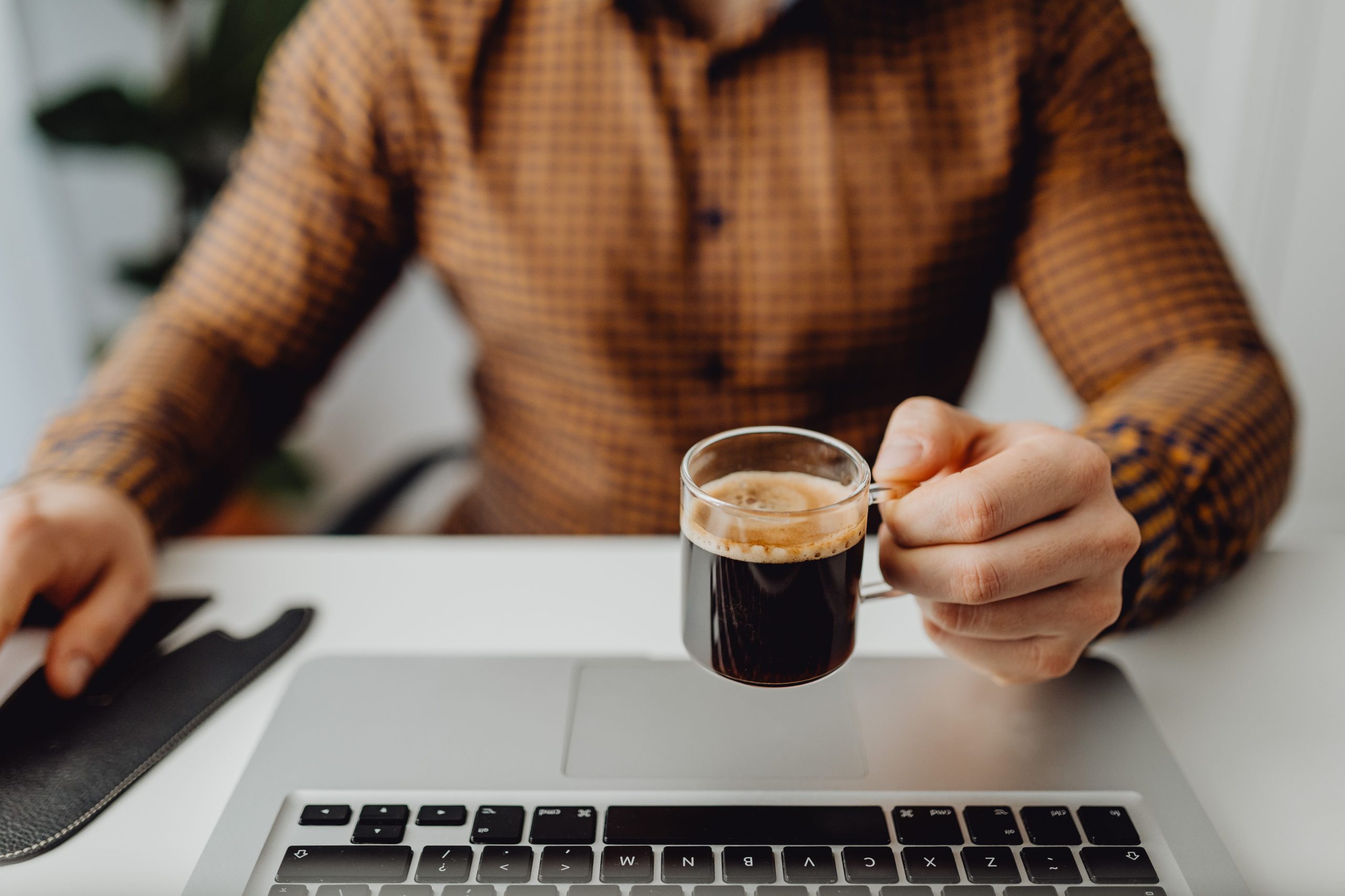 Homme travaillant sur laptop avec café au bureau